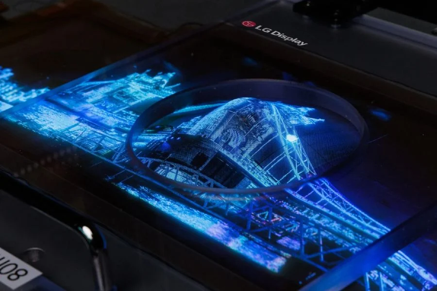 écran extensible OLED transparent de LG Display affichant une image lumineuse et détaillée d'un pont illuminé en bleu. L'écran présente une haute résolution et une transparence partielle, mettant en valeur la technologie avancée d'affichage.