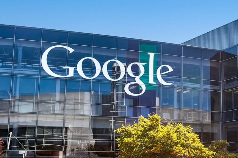 Façade vitrée du siège de Google avec son logo emblématique, reflétant l’architecture moderne et l’innovation technologique de l’entreprise. et